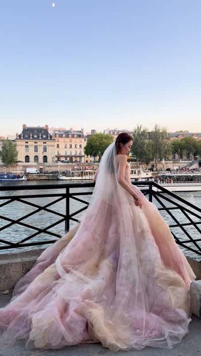A bride in a blush gown on a bridge